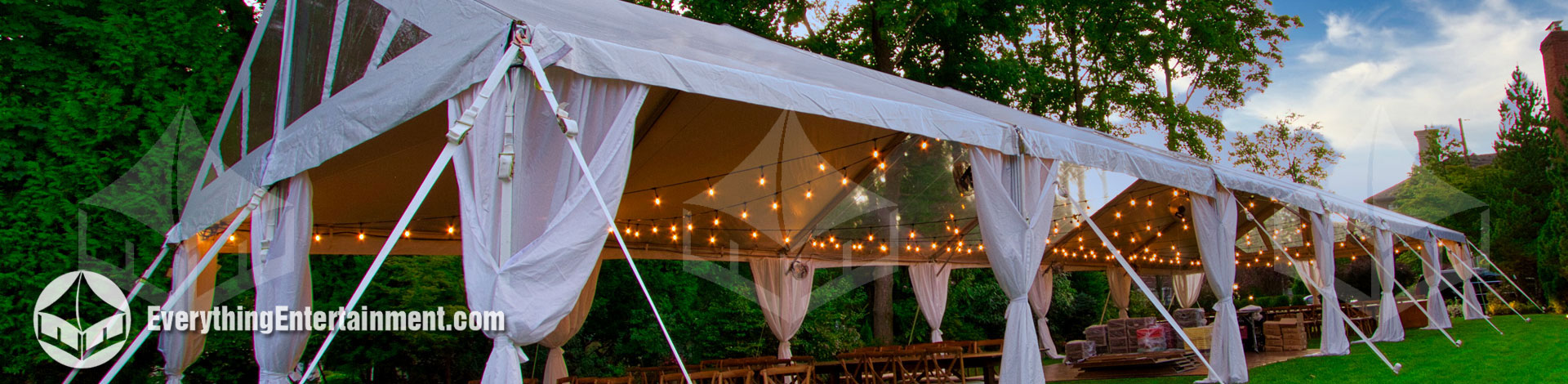 long 30x90 foot tent setup in backyard with rustic decor.