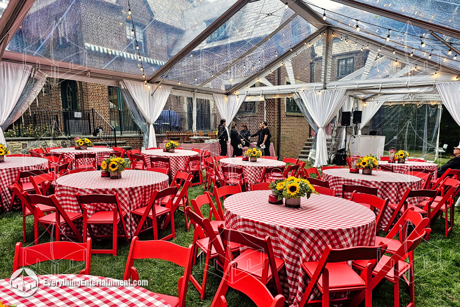 A large 30x50 clear top tent with red and white linens, chairs, and more.