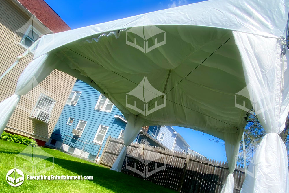A 15x15 high peak marquee tent with fabric liner in backyard