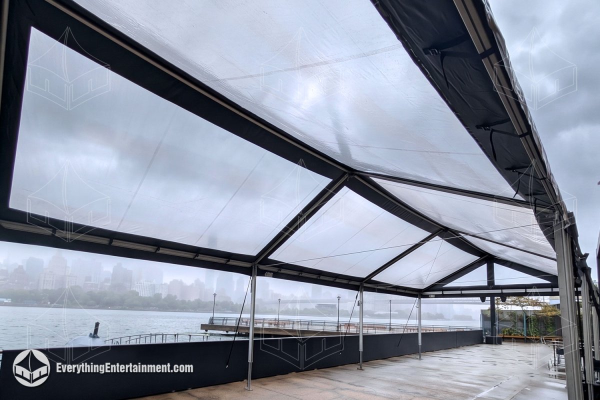 Interior view of a clear top frame tent with black vinyl trim installed on an East River waterfront pier in Long Island City, NY by Everything Entertainment.