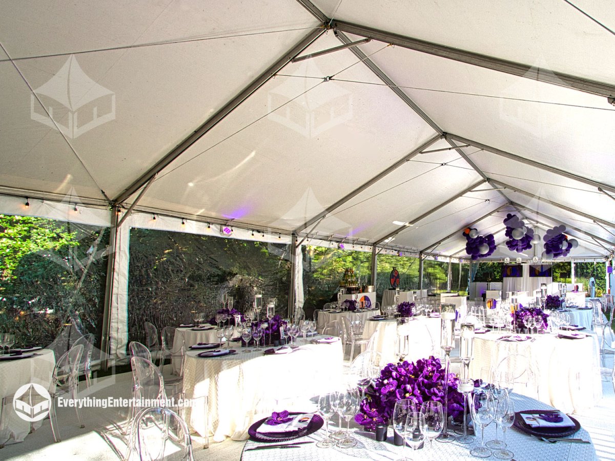 Interior view of a 30x90 frame tent with clear sidewalls, white carpeted subfloor, white dance floor, and purple party decor installed for a Sweet 16 in New Jersey by Everything Entertainment.