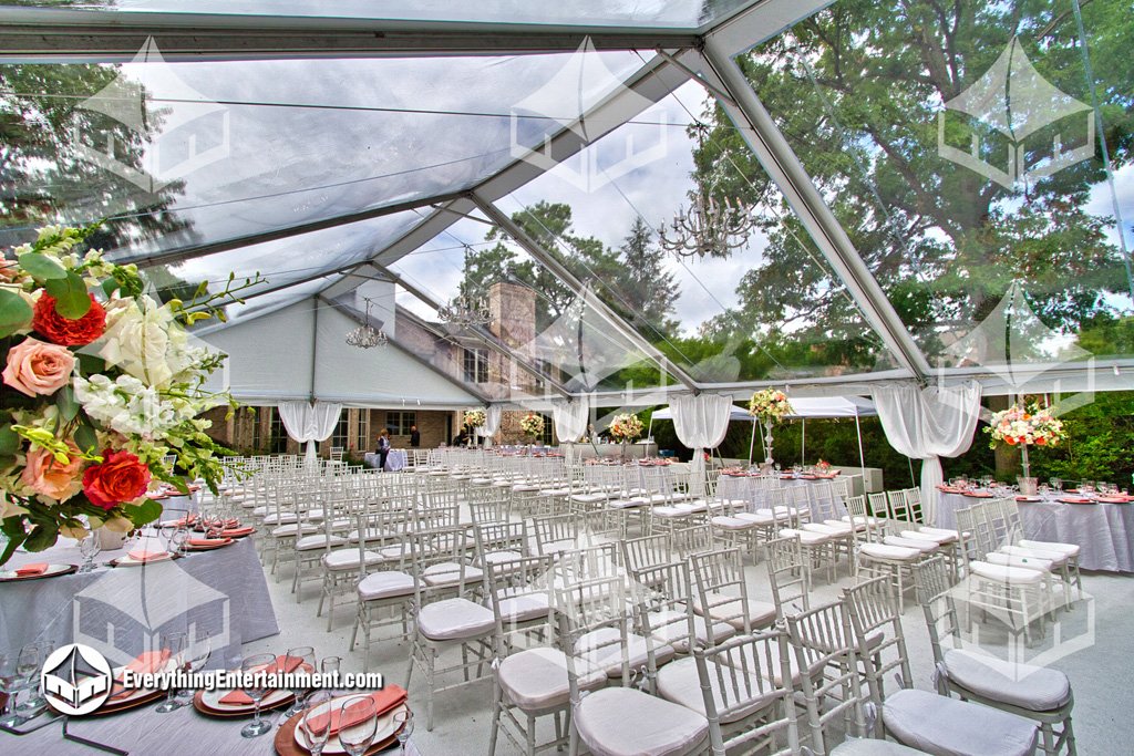 Elegant 40x75 clear top wedding tent with white carpeted subfloor, chandeliers, and Chiavari chairs set up in a Teaneck NJ backyard by Everything Entertainment.
