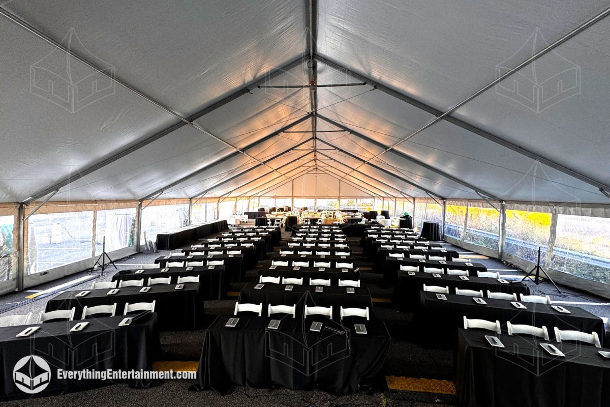 High-angle aerial view of a 50x120 white maxi-frame tent with ballasts and HVAC heating units set up on an asphalt parking lot in Secaucus NJ by Everything Entertainment.