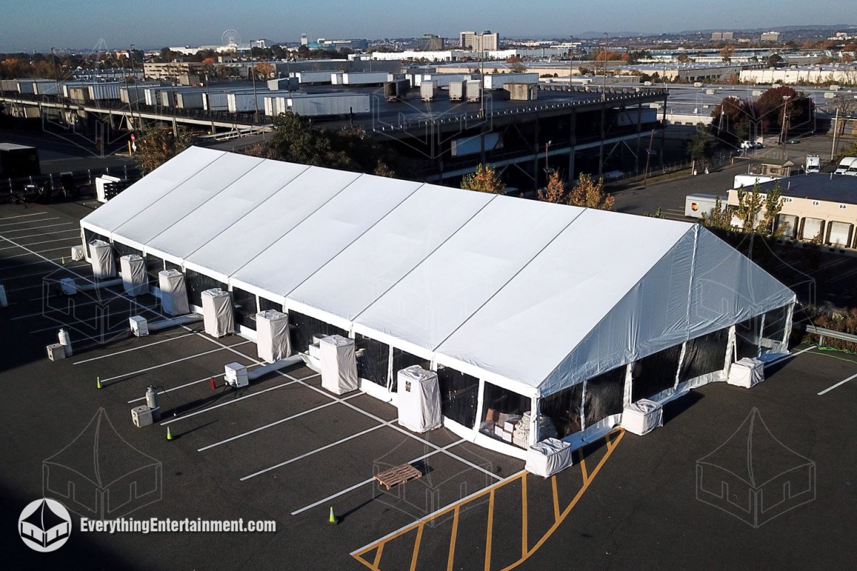 High-angle aerial view of a 50x120 white maxi-frame tent with ballasts and HVAC heating units set up on an asphalt parking lot in Secaucus NJ by Everything Entertainment.