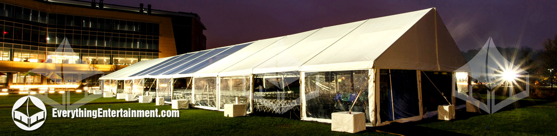 large 50x200 foot tent setup on grass in courtyard of business