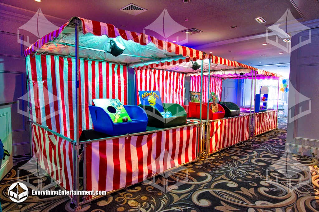 Three red and white striped carnival booths inside a catering hall.