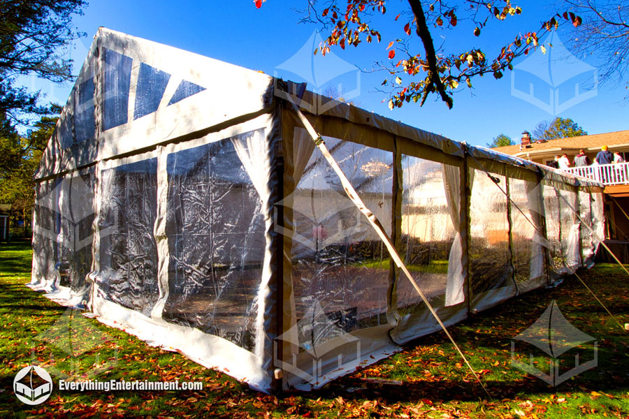 Clear tent sidewalls on a large 30x60 foot frame tent setup on grass with f