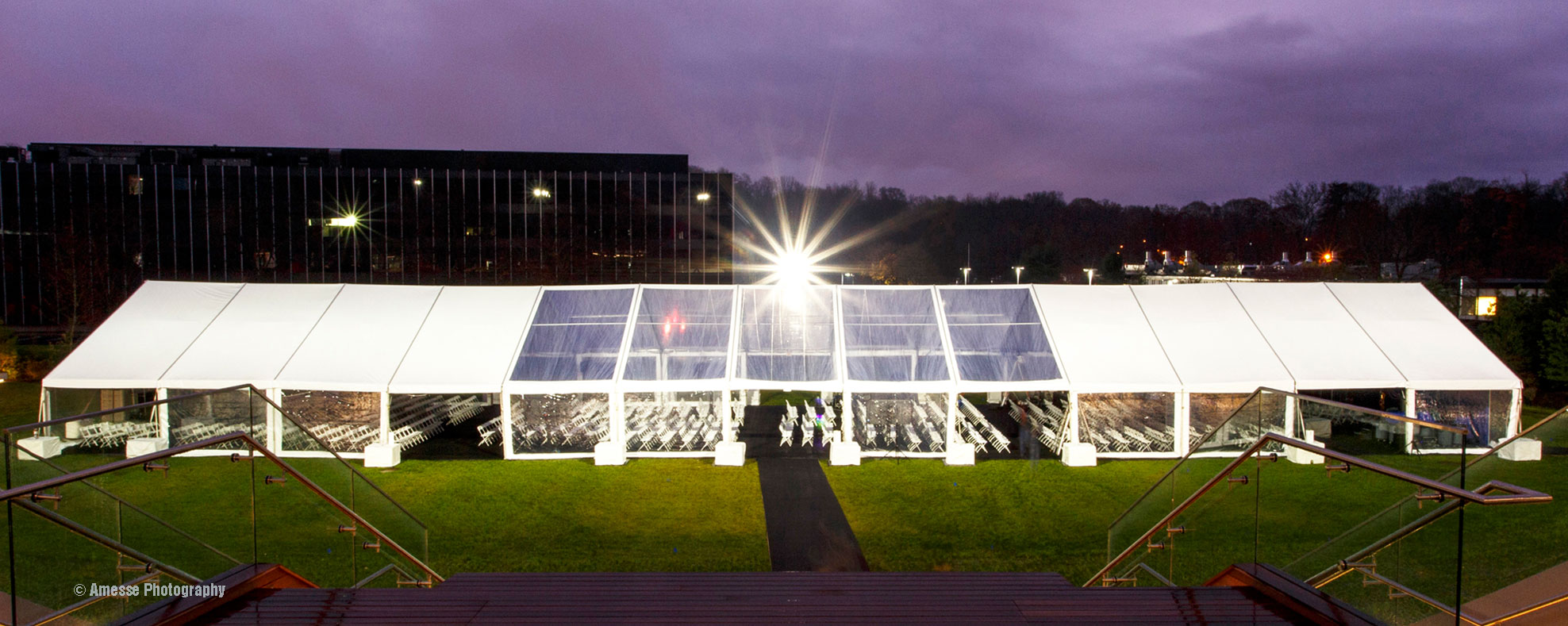 A huge tent set up with a thousand chairs for a corporate event