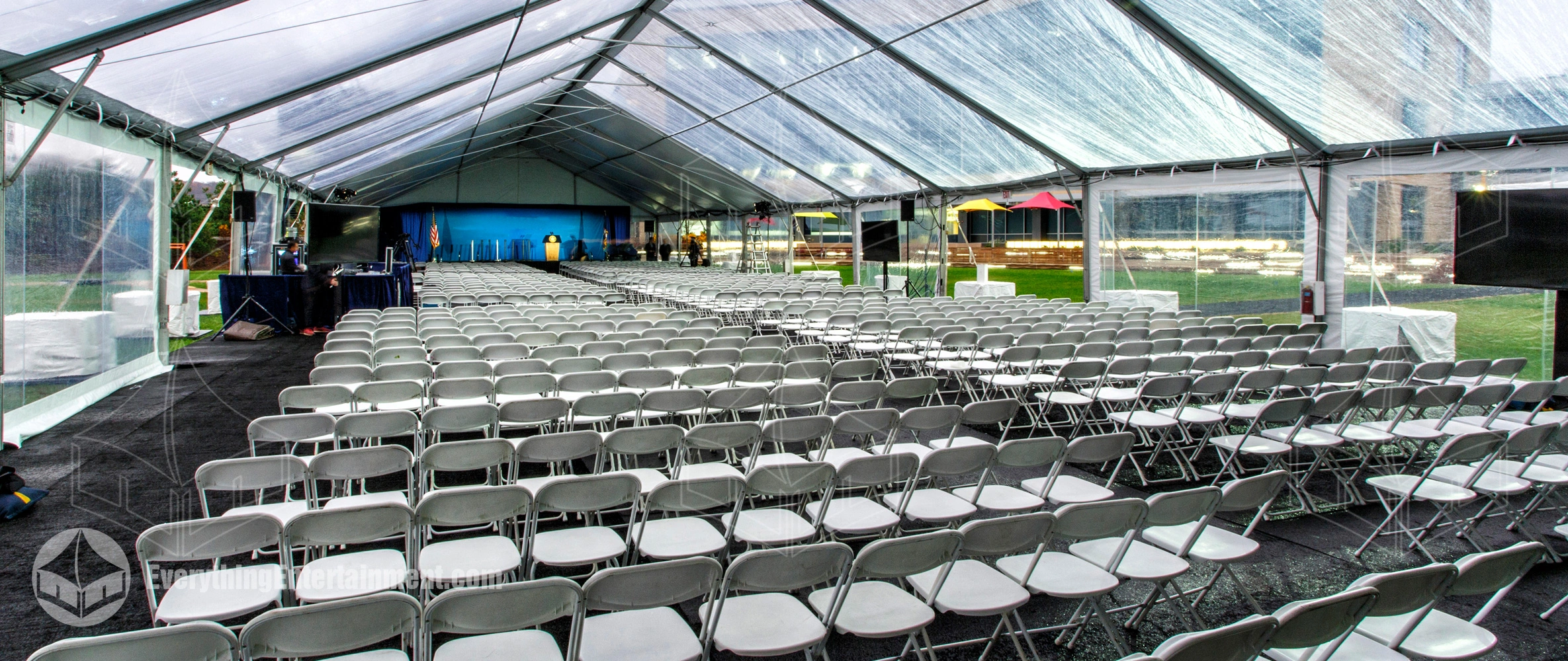 A huge rental tent set up with a thousand chairs and a stage for a corporate event in Tarrytown, NY for a pharmaceutical company