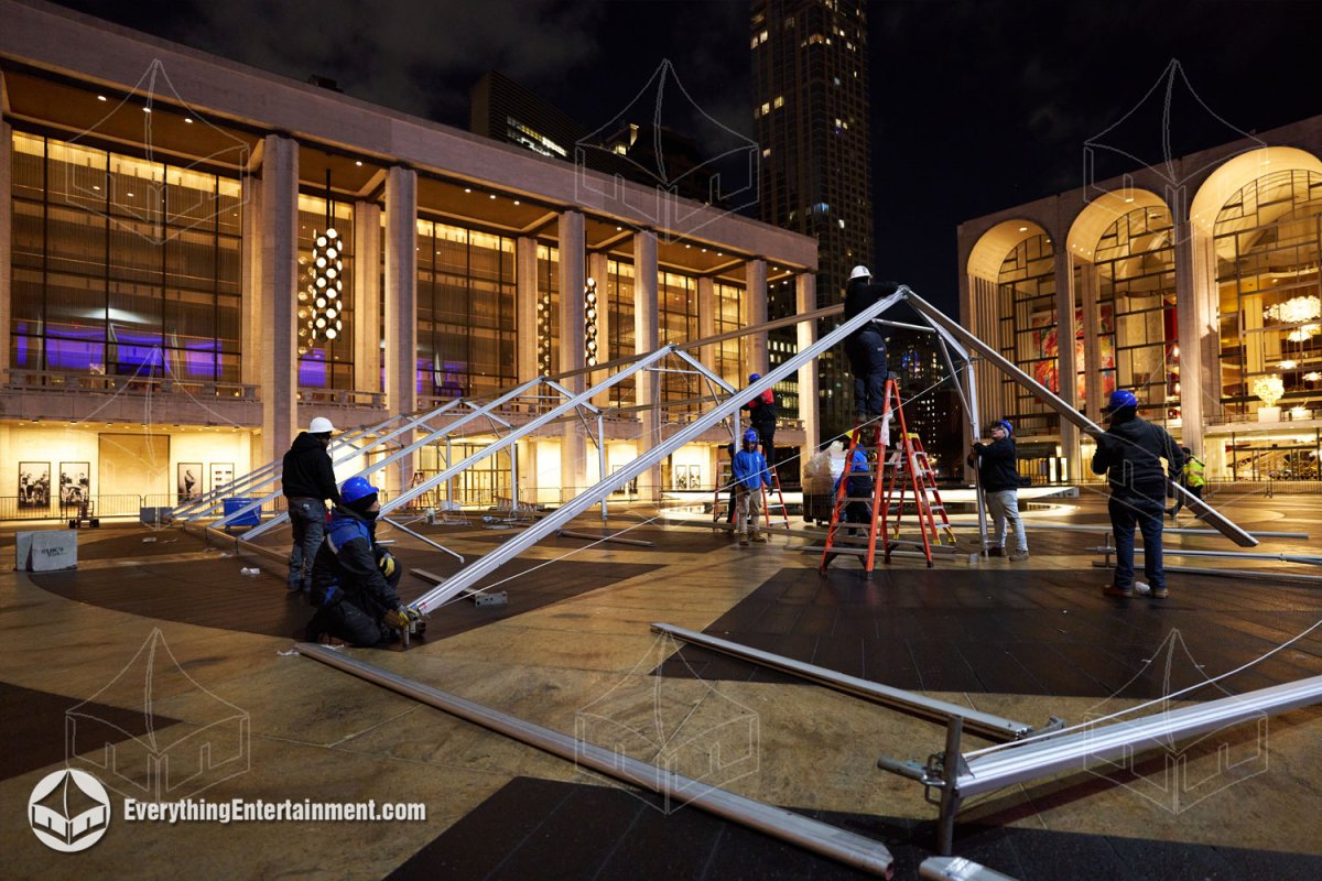 Installation crew securing structural tent frame joints during a night setup at Lincoln Center in NYC.