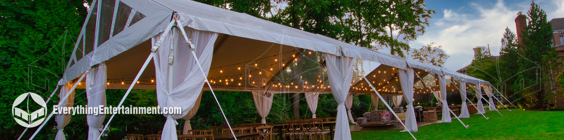 long 30x90 foot tent setup in backyard with rustic decor.