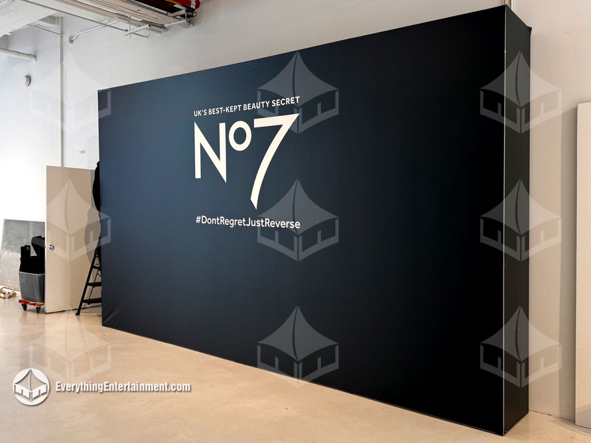 Freestanding black SEG fabric media backdrop wall with No7 branding custom built for an indoor event in NYC by Everything Entertainment.