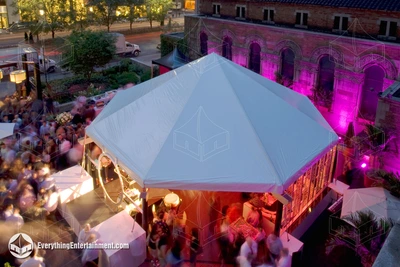 An octagon shaped tent with LED uplighting illuminating the wall on the raised deck at St Barts Church in NYC