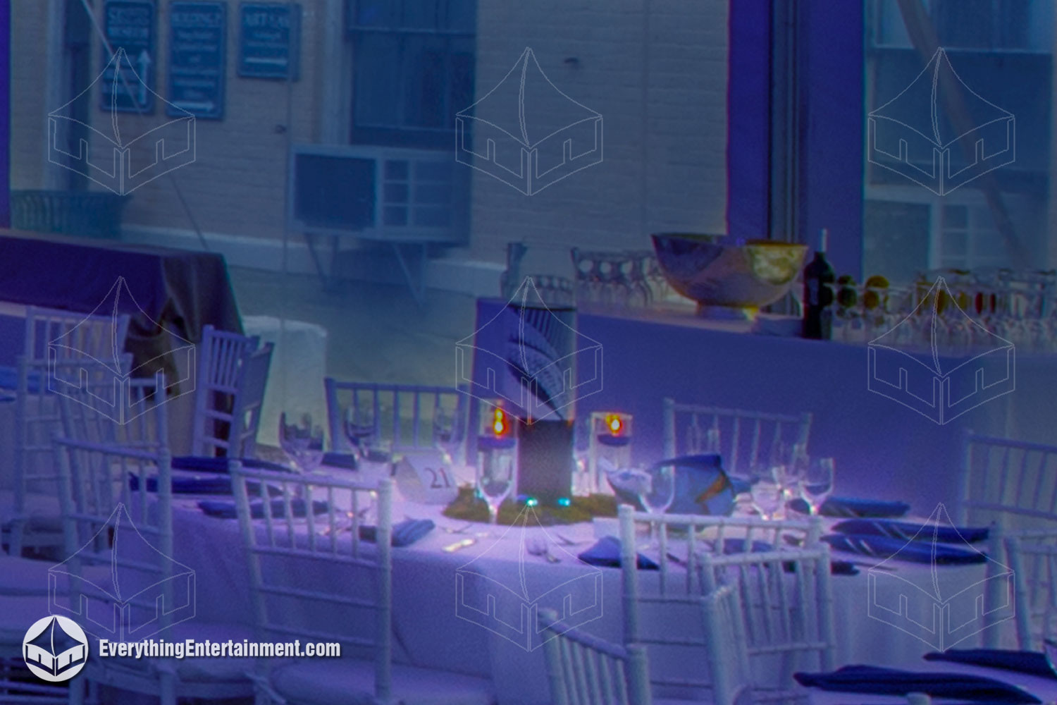 Table with pin spot lighting, in a tent washed with blue lights