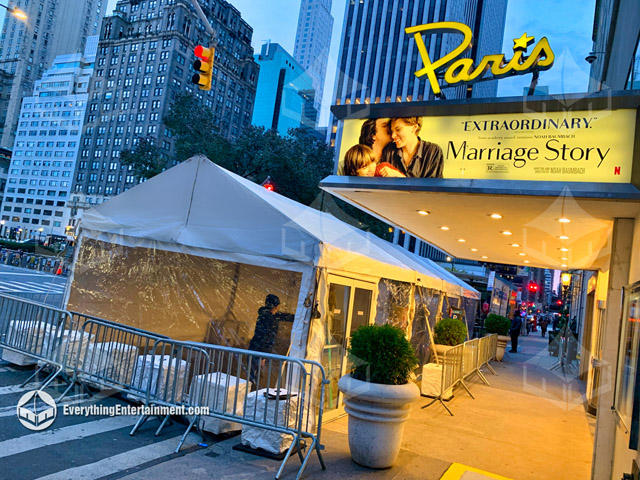 Exterior of a frame tent with clear walls and white top in front of The Paris Theater in New York