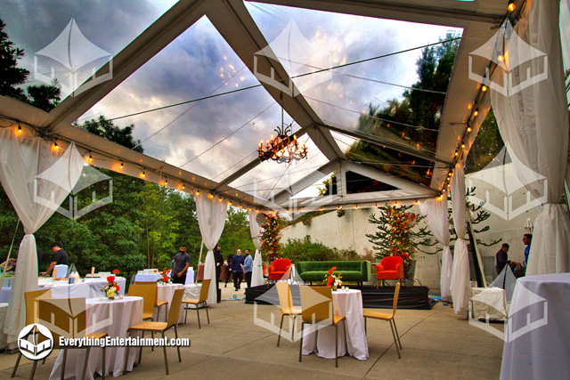 A 20x35 Glass Top Frame Tent setup at Brooklyn Botanic Gardens for a wedding, compete with string lights and leg drapes.