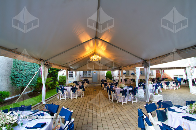 White top frame tent with chandelier and party rentals for an outdoor school prom.