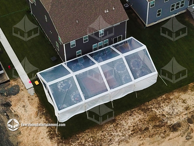 A 30x60 Glass Top frame tent rental setup for a backyard party