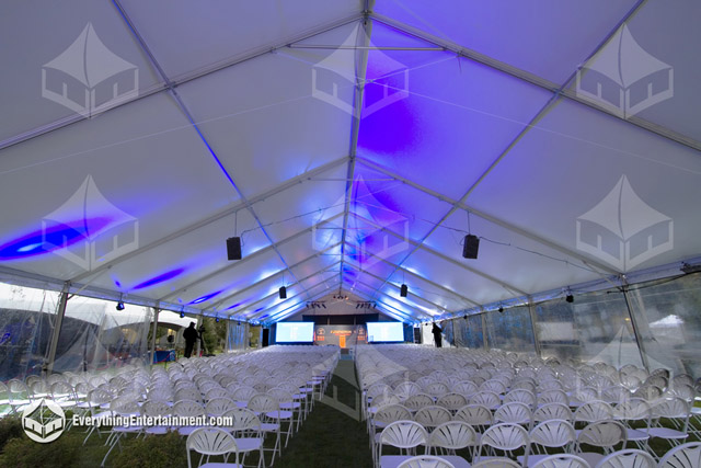 1000 chairs setup inside a large frame tent with stage in distance.
