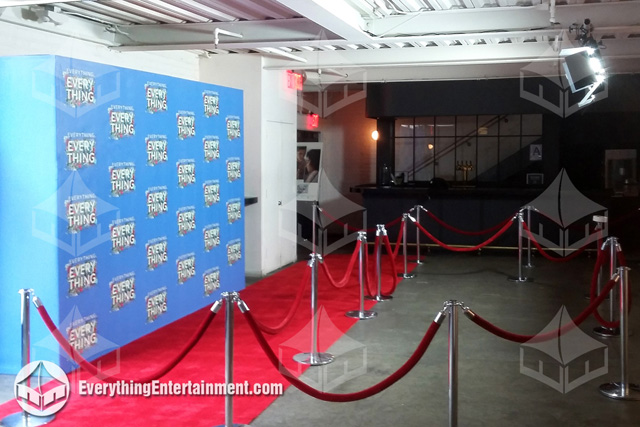 Step and repeat wall with red carpet, stanchions and ropes, inside NYC theater.