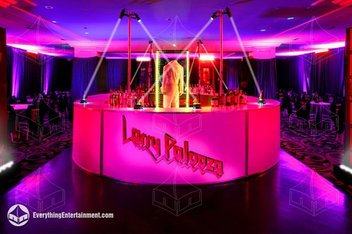 round branded bar in room with event lighting and dance floor