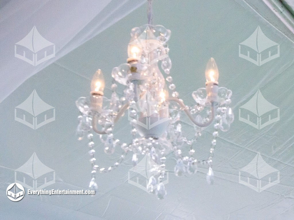 Crystal Chandeliers hanging in a 10x200 frame tent with white fabric swags