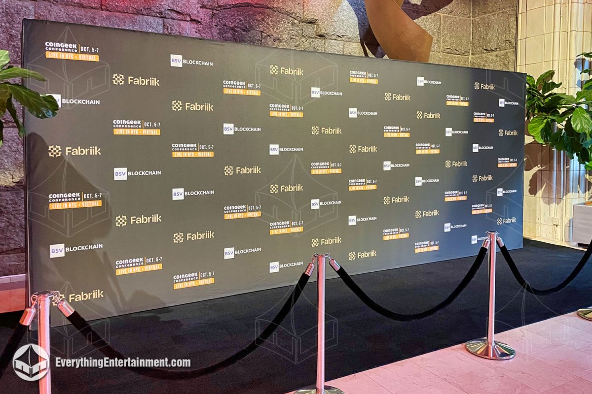 Large-format matte black CoinGeek step and repeat media backdrop wall with stanchions and velvet ropes installed in NYC by Everything Entertainment.