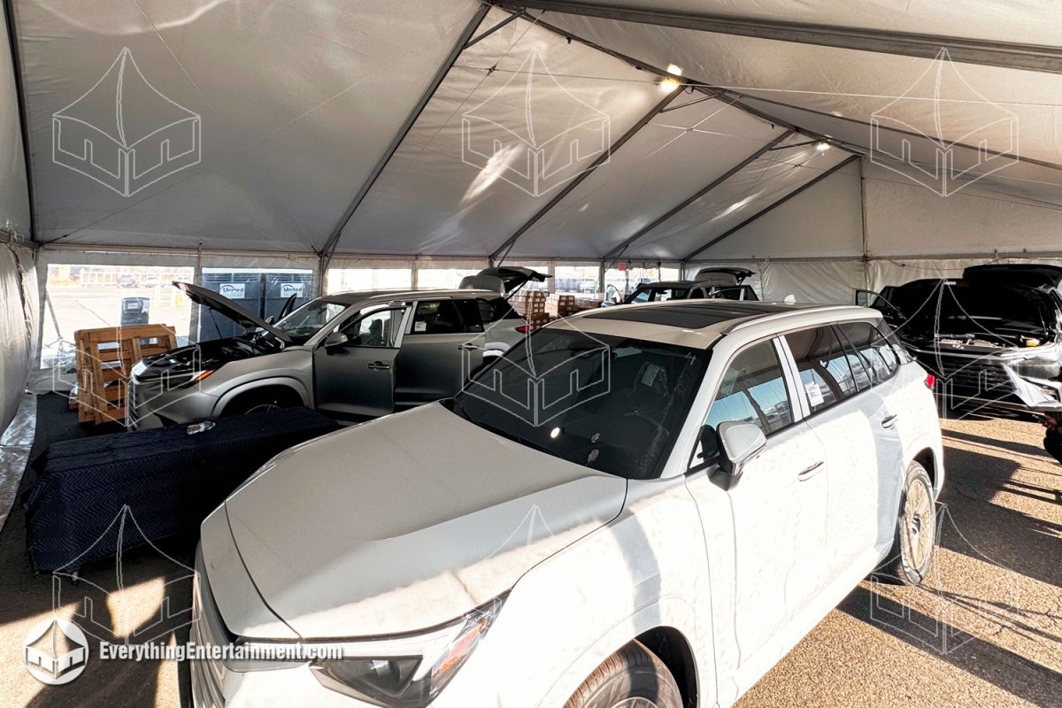 Interior view of a 40x60 temporary warehouse frame tent with overhead lighting and heating used for vehicle detailing and automotive work by Everything Entertainment.