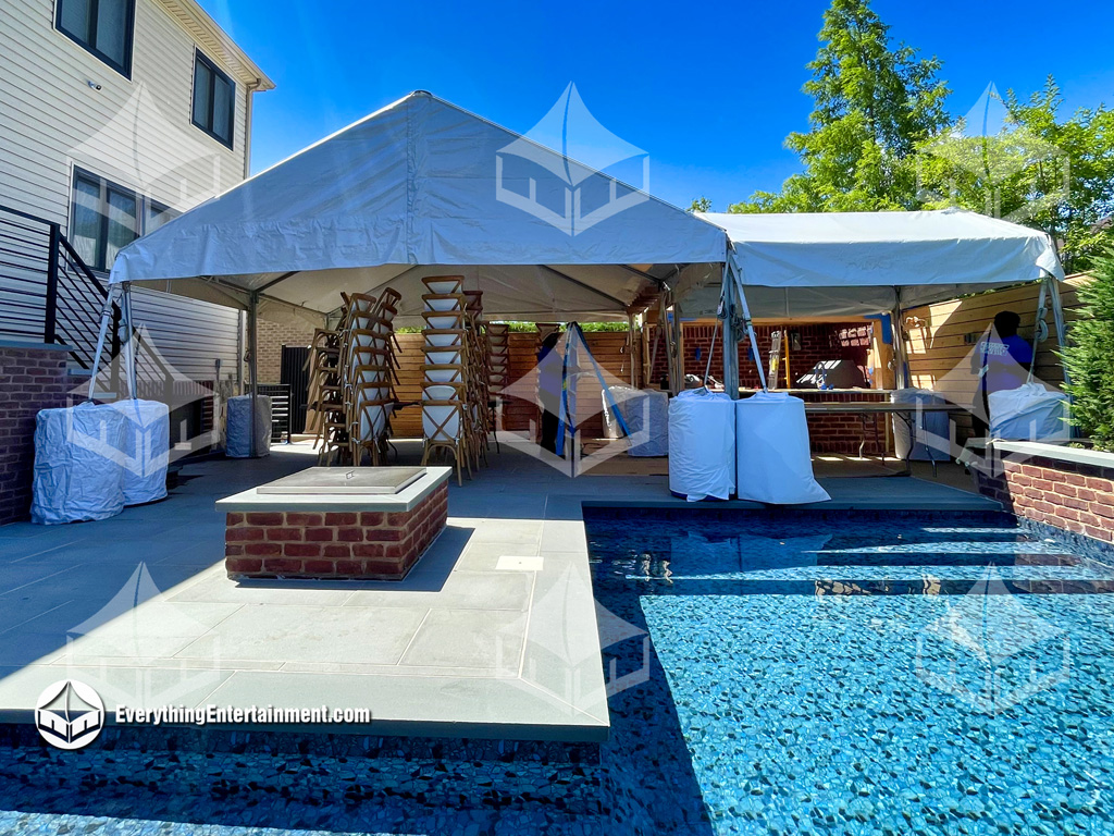 Tent setup in a backyard with water weights attached