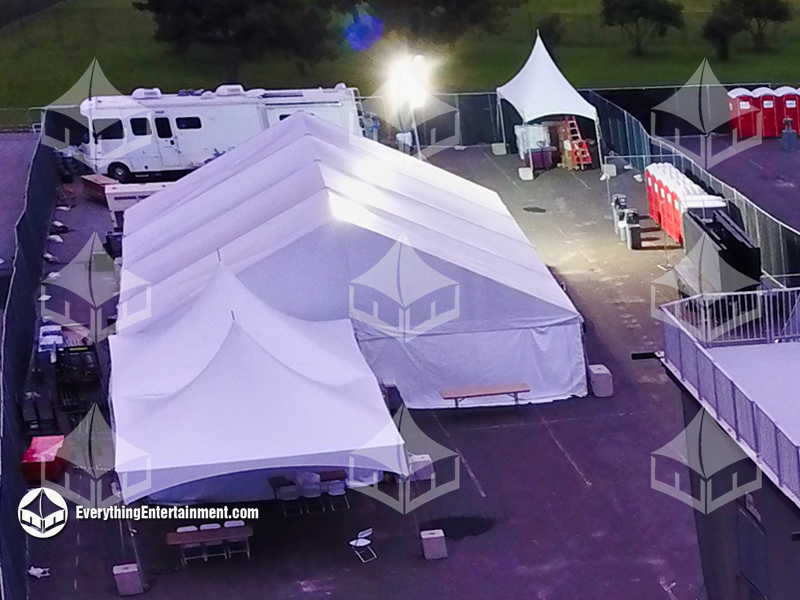 Tents setup for television shoot in asphalt lot.