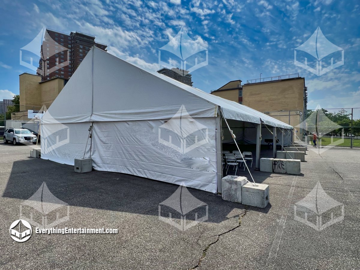 Large white clearspan frame tent with sidewalls set up on a playground lot for a school commencement ceremony by Everything Entertainment in Staten Island.
